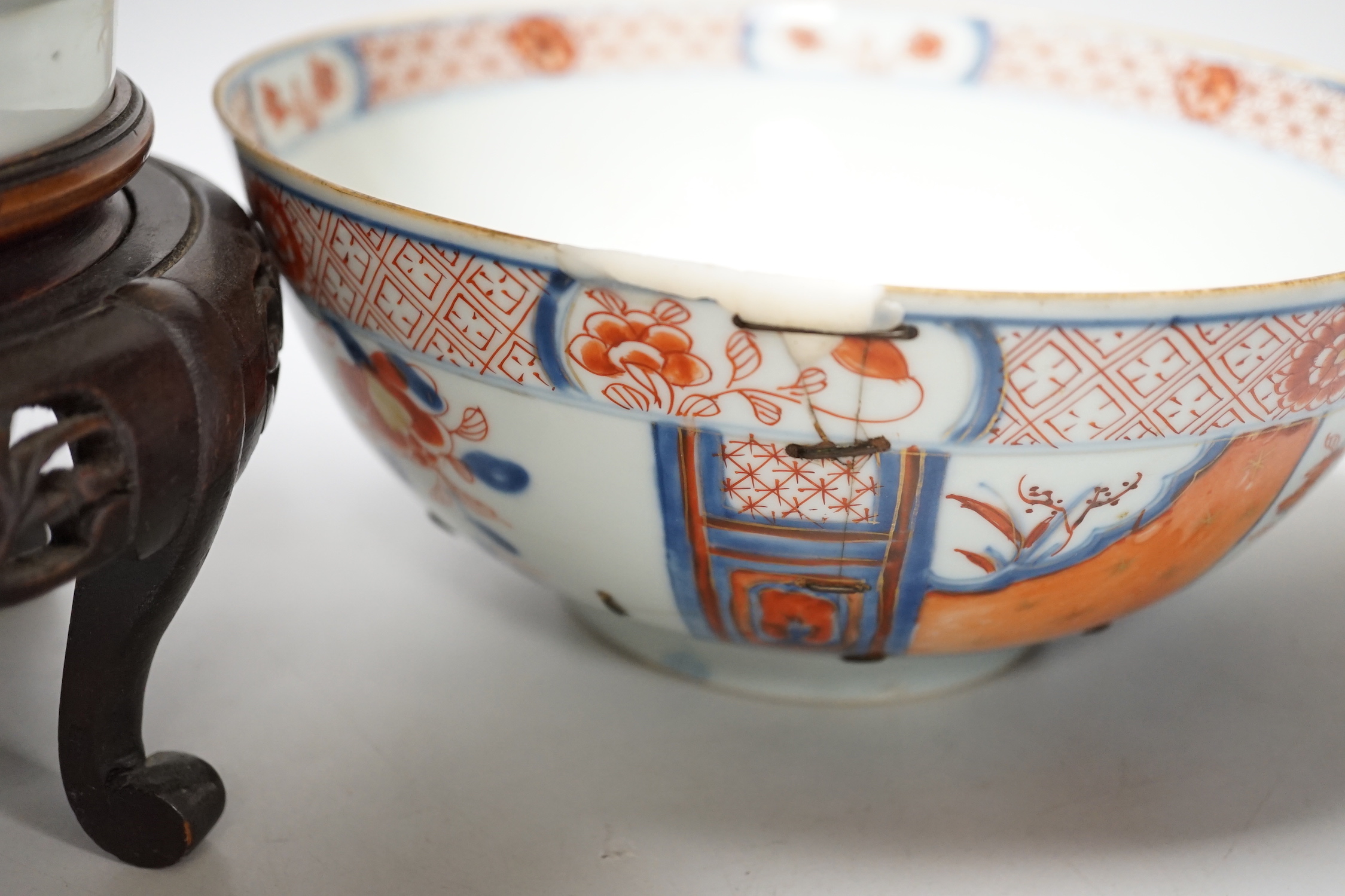 Four 18th century Chinese porcelain bowls (a.f), one with hardwood stand, largest 28cm diameter